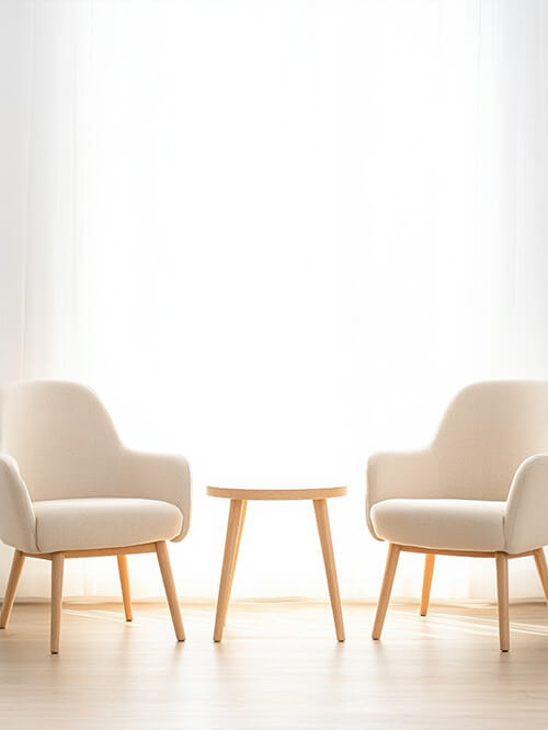 Zwei helle, bequeme Stühle stehen bereit für ein Kennenlerngespräch